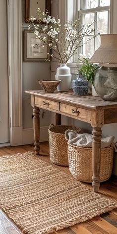 a wooden table topped with baskets and vases on top of a hard wood floor