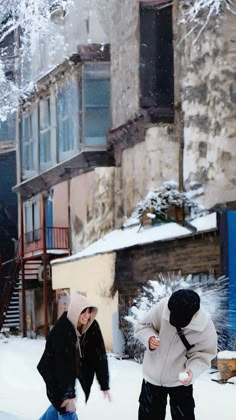 two people are playing in the snow outside