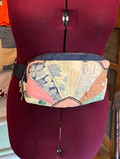 a woman's torso wearing a fanny bag made out of fabric and leathers