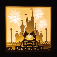 the silhouette of mickey and minnie mouse in front of a castle