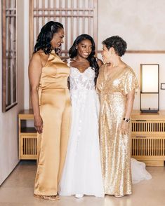 three women standing next to each other in formal wear and one is wearing a gold dress