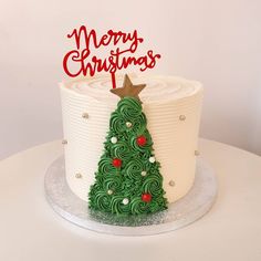 a decorated christmas tree cake sitting on top of a table