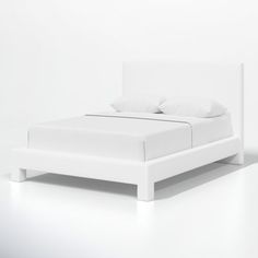 a bed with white sheets and pillows on it