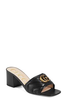 Alessandro Michele culls the house's rich history with this slide sandal in matelassé leather embellished with gleaming Marmont hardware first seen in the '70s. 2 1/2" (64mm) heel ( size 38.5) Leather upper, lining and sole Made in Italy Women's Designer Shoes Gucci Marmont Sandals, Luxury Slide Mules, Luxury Slides With Buckle Closure, Luxury Leather Sole Slide Mules, Luxury Slides With Padded Heel, Luxury Mules With Padded Open Heel, Luxury Spring Mules With Buckle Closure, Luxury Mules With Buckle Closure For Spring, Luxury High Heel Mules With Padded Heel