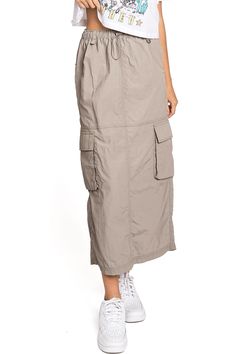 Chic, parachute skirt with an elastic waistband, a drawstring cinch tie and cargo pockets down the sides. Pair it with a graphic tee and sneakers for an effortless streetwear look. CARE | Machine Wash Cold CONTENTS | 100% Nylon MEASUREMENTS | 33"/85 cm Top to Bottom (Size Small) MODEL | 5'8 - wearing a size Small IMPORTED Summer Utility Parachute Pants For Outdoor Activities, Casual Cargo Skirt With Drawstring For Summer, Casual Drawstring Cargo Skirt For Summer, Casual Summer Cargo Skirt With Drawstring, Spring Utility Cargo Skirt With Drawstring, Casual Parachute Pants For Spring Outdoor Activities, Casual Summer Cargo Skirt, Utility Cargo Skirt With Elastic Waistband, Cotton Cargo Skirt With Drawstring For Spring