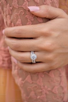 a close up of a person's hand with a diamond ring on their finger