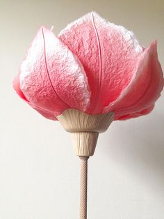 a pink flower is sitting on a stick