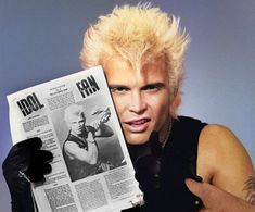 a man with blonde hair holding up a newspaper