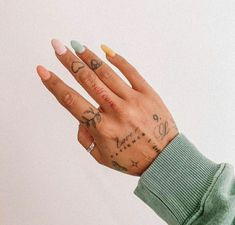 a woman's hand with tattoos on her left wrist and right hand in the air