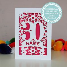 a red and white greeting card with the number 30 on it, surrounded by colorful pom poms