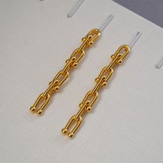 Add a touch of playfulness to your ensemble with our ulink chain earrings. With a 6cm drop length, these minimalist earrings are both feminine and quirky. Pair them with any outfit for a unique and fun look! Finish: 18K gold Drop length approx. 6cm Trendy Gold Dangle Linear Earrings, Trendy Gold Linear Earrings For Everyday, Trendy Long Drop Linear Earrings, Gold Linear Dangle Earrings With Box Chain, Delicate 14k Gold-filled Long Drop Earrings, Long Drop Gold-tone Linear Earrings, 14k Gold-filled Drop Earrings With Adjustable Chain, Gold-plated Long Drop Linear Earrings With Adjustable Chain, Long Tassel Earrings