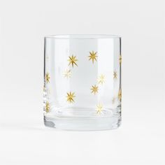 a clear glass with gold stars on the inside and bottom, in front of a white background