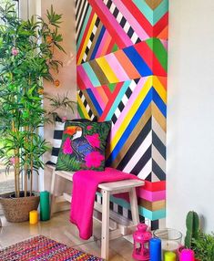 a brightly colored wall in the corner of a room with potted plants and a bench