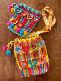 two crocheted purses sitting on top of a wooden table