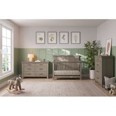 a baby's room with green walls and furniture