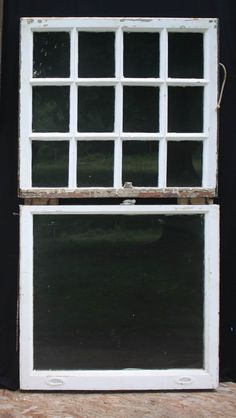 an old white window sitting on the side of a black wall next to a door