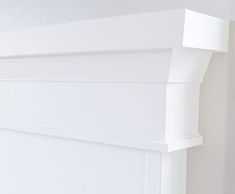 the corner of a white painted room with moldings on the wall and below it