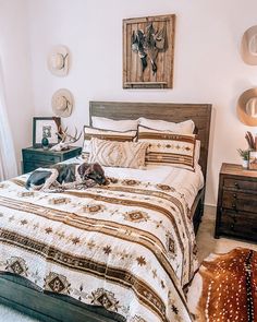 a bed room with a neatly made bed and two deer head mounted on the wall