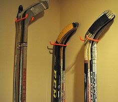 three pairs of skis are hanging up on the wall next to each other,