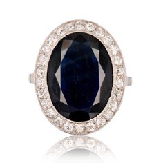 Ring in platinum, dog head hallmark. Sublime art deco ring, it is set with an oval navy blue sapphire in a surround of antique brilliant- cut diamonds. The basket of the setting is delicately openworked with arabesques. Weight of the sapphire : 7 carats approximately. Total weight of the diamonds : 0.50 carat approximately. Height : 21.2 mm, width : 17 mm, thickness : 4.4 mm, width of the ring at the base : 1.3 mm. Total weight of the jewel : 6 g approximately. US Size : 6 ; Free resize, please Art Deco Oval Sapphire Ring In Platinum, Antique Oval Sapphire Diamond Ring, Antique Oval Sapphire Ring With Polished Finish, Antique Oval Sapphire Ring In Platinum, Antique Oval Sapphire Ring In White Gold, Platinum Diamond Rings, French Art Deco, Platinum Ring, Art Deco Ring