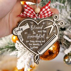 a wooden ornament hanging from a christmas tree with scissors and combs on it