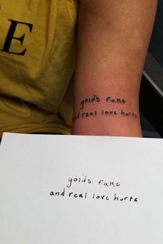 a person holding a piece of paper with writing on it that says god's love and real love hurts