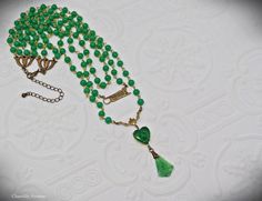 "A gorgeous Jade glass multi strand Art Deco necklace in classic Egyptian Revival style with vintage jade glass beads and cabochons. It makes the perfect handmade women's gift for anyone who loves vintage style Egyptian jewelry. Made from strands of 6mm vintage Cherry brand jade glass beads, a brass Sphinx connector charm, and a 14mm Jade glass heart-shaped scarab with a textured, mixed light and dark Jade glass fan pendant. The smallest row in this necklace measures 15\" closest to the throat, Vintage Jade Jewelry For Jewelry Making, Antique Green Beaded Necklace As Gift, Antique Beaded Necklace With Faceted Beads As Gift, Antique Beaded Necklaces With Faceted Beads As Gift, Antique Beaded Necklace With Faceted Beads For Gift, Antique Green Beaded Necklace For Gift, Vintage Double Strand Gemstone Bead Jewelry, Vintage Glass Jewelry With Gemstone Beads, Vintage Glass Beaded Necklaces For Gifts