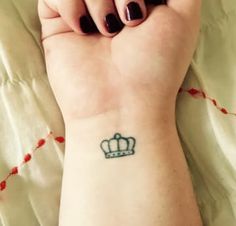 a woman's wrist with a crown tattoo on her left arm and the words, i got this crown to remind that i am queen and she