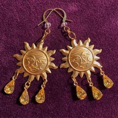 Bring a solar smile to the face of all that look upon your beauty with these dazzling sun drop earrings. These little works of art feature raw stamped brass charms of the smiling sun, and from the smiling sun hangs three vintage pear cut jonquil yellow glass charms. These glass charms have undertones of red, orange, yellow, and green to keep the spectrum of the sun sparkling around you! The earring hook has a clear glass crystal charm and is plated in 22k gold which is perfect for sensitive ears Adjustable Sun Design Jewelry, Gold Sunburst Earrings With Sun Design, Celestial Sun Design Dangle Jewelry, Gold Sun And Moon Festival Jewelry, Festival Sun And Moon Dangle Jewelry, Gold Celestial Earrings With Sun Design, Gold Sunburst Earrings For Gift, Gold Sun And Moon Design Jewelry For Festivals, Metal Sun Design Earrings For Gift