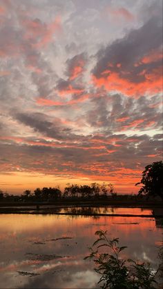 the sky is reflecting in the water at sunset