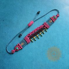 a pink beaded necklace on a blue surface