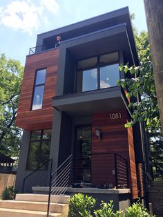 a modern house with wood siding and metal railings