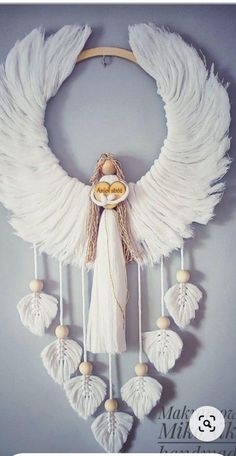 a white angel with wings hanging on the wall