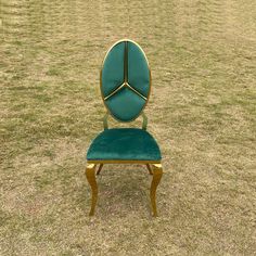 a green chair sitting on top of a grass covered field