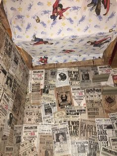 the toilet is covered with newspaper paper and has pictures all over it's walls