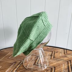 a green hat sitting on top of a wooden table