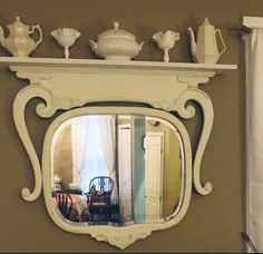 a mirror that is on the side of a wall next to a table and chair