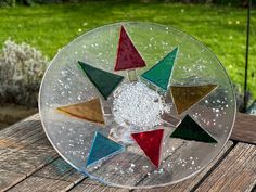 a glass plate sitting on top of a wooden table covered in sand and sea salt