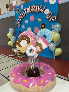 a birthday party with donuts and balloons in the shape of doughnuts on display