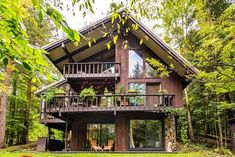 a large wooden house in the woods surrounded by trees