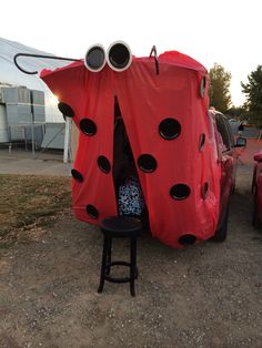 a ladybug tent sitting next to a red car