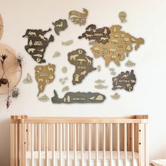 a baby's room with a crib and wall hangings that have animals on them