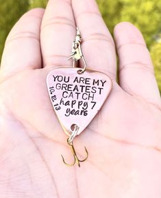 someone is holding up a fishing hook with the words you are my greatest catch on it