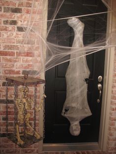 the skeleton is wrapped in plastic to look like it's coming out of the door