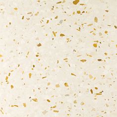 a white and gold speckled surface with lots of small pieces of paint on it