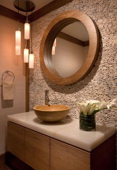 a bathroom with a round mirror above the sink and a wooden bowl on the counter