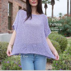 a woman wearing a purple sweater and jeans standing in front of some bushes with her hands on her hips