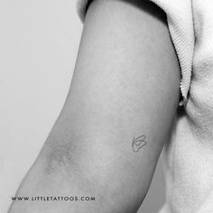 a woman's arm with a small heart tattoo on the left side of her arm