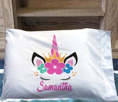 a pillow with a unicorn face and flowers on it