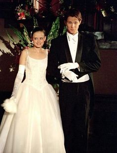 a man in a tuxedo standing next to a woman in a wedding dress